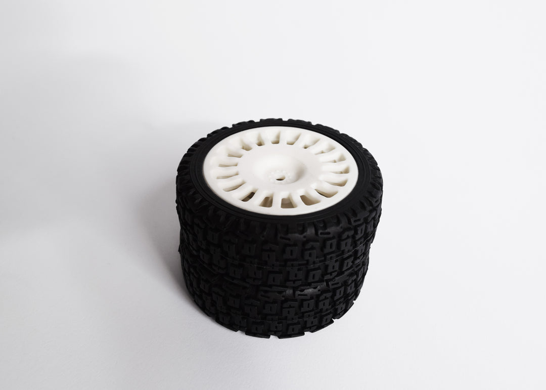 A 4-piece rally tyre set with block-type tread, 18 spokes, and 25/66mm wheels, including wheel spacers