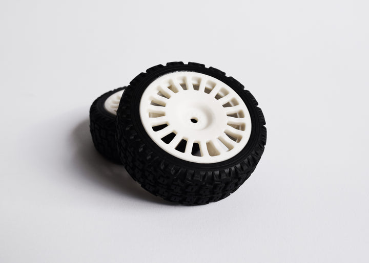 A 4-piece rally tyre set with block-type tread, 18 spokes, and 25/66mm wheels, including wheel spacers